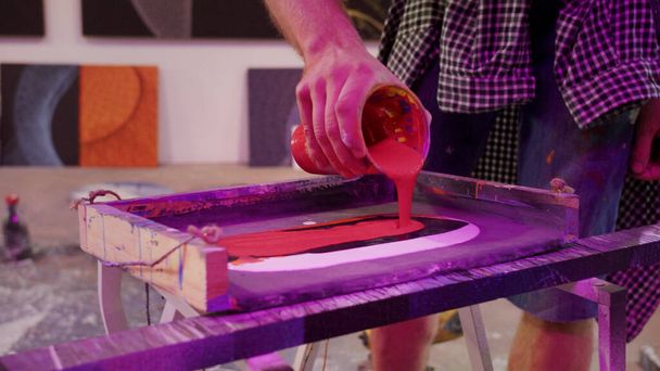 A handsome painter is mixing paints in a pallete - Photo, Image