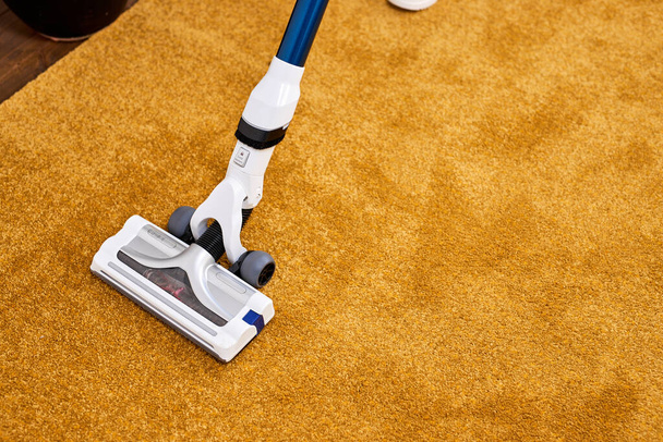 Unrecognizable person using vacuum cleaner at home, closeup - Foto, afbeelding