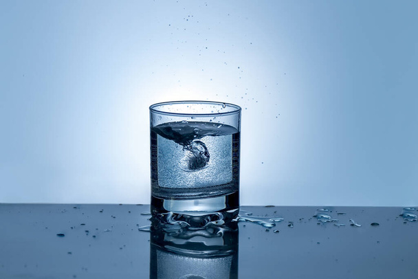 Splash of water in a glass. Splashing water. Ice water. Concept. - Фото, изображение