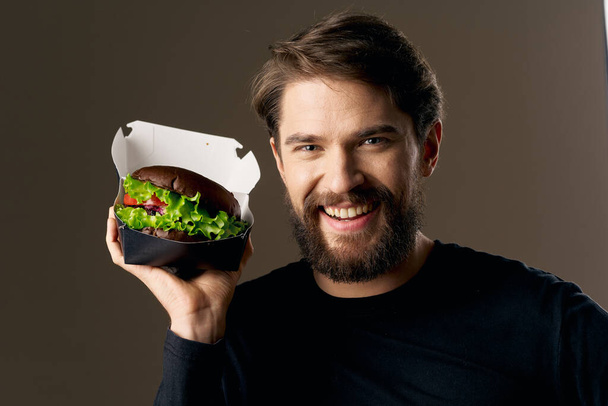 szakállas férfi hamburgerrel gyorskaja diéta étel ínyenc étterem - Fotó, kép