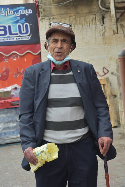 Jeruzsálem Izrael 2021. március 27.: Azonosítatlan sapkás férfi, a főváros arab kerületének bennszülött lakosa, idős nyugdíjas bottal. Kiváló minőségű fénykép - Fotó, kép