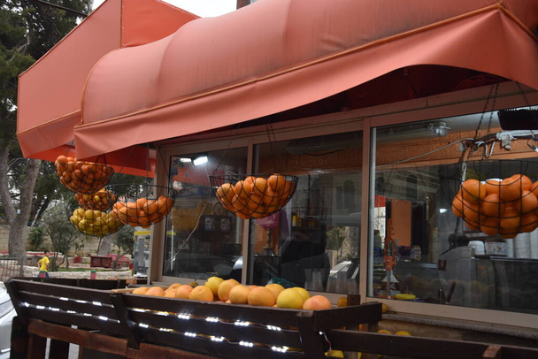 Jerusalem Israel 27. März 2021: arabischer Laden mit Orangen für frischen Saft, Straße mit Auto und Mann. Hochwertiges Foto - Foto, Bild