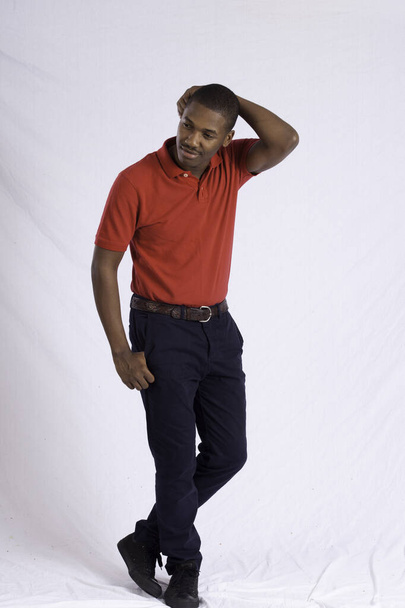 Happy Black man in a red shirt with his hand on his head - Photo, Image
