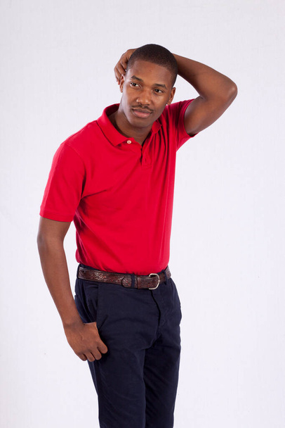 Happy Black man in a red shirt with his hand on his head - Photo, Image