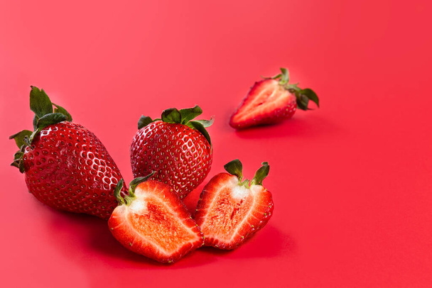 Strawberry. Fresh strawberries on a red background. Red on red. Copy space. Place for your text. High quality photo - Photo, image