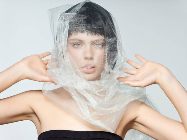 woman with black hair and a package on her head naked shoulders dress model - Fotoğraf, Görsel