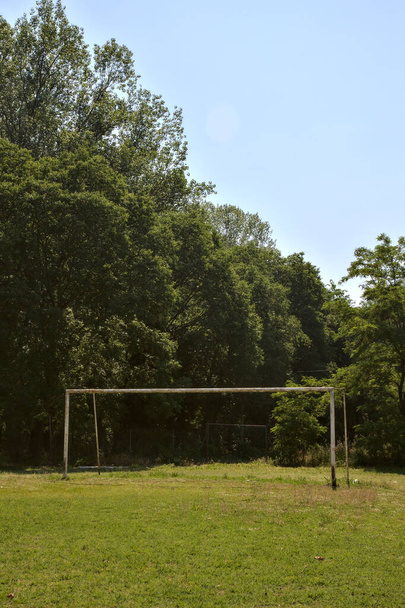 Campo de fútbol vacío con un gol en un parque al mediodía - Foto, imagen