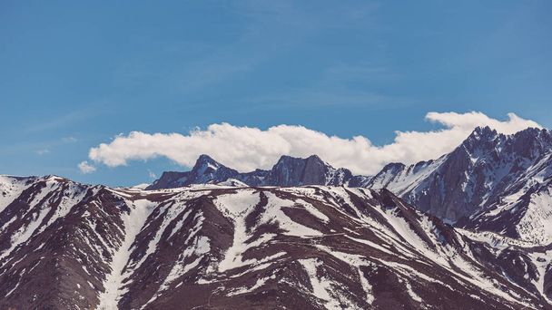 Snow capped Sierra Nevada Mountains against blue sky with clouds - Zdjęcie, obraz