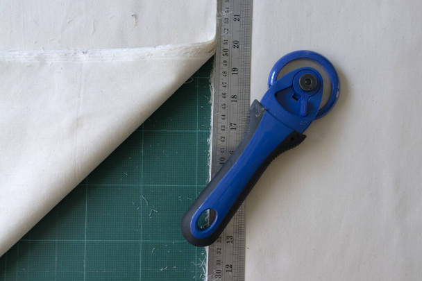 на коврике для лоскутного шитья есть нож для лоскутного шитья, линейка, - Фото, изображение