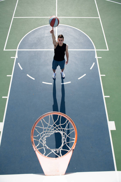 Basketball player shooting ball in hoop outdoor court. Urban youth game. Concept of sport success, scoring points and winning. - Фото, зображення
