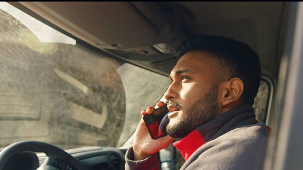 Young delivery guy driving a van while talking on phone Parcel delivery concept - Photo, Image