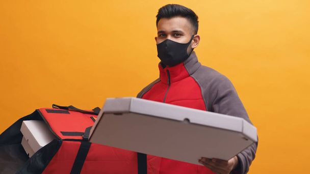 Livraison Garçon portant Masque portant des boîtes à pizza dans une boîte de colis rouge Livraison à domicile - Photo, image