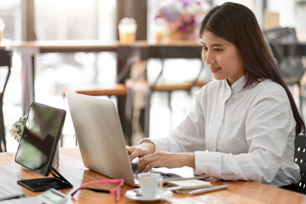 Charmosa mulher de negócios asiática sentada trabalhando no laptop no escritório - Foto, Imagem