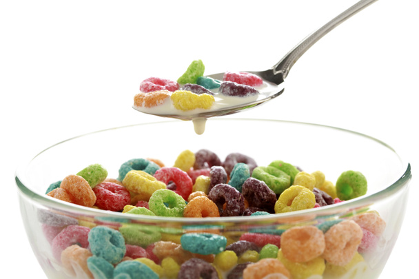Colorful fruit cereal loops in a bowl. Fruit Loops in a Bowl of milk. isolated on white. room for text. breakfast cereal in a spoon. a spoon full of cereal. breakfast food. quick breakfast for kids. - Photo, Image