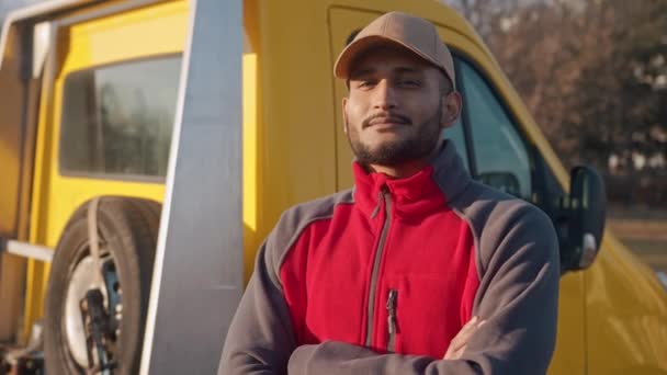Mladý dělník stojící s rukama zkříženýma kývnutím na kamerový automechanik - Záběry, video
