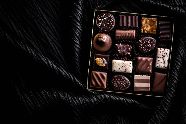 Ελβετικές σοκολάτες σε κουτί δώρου, διάφορες πολυτελείς πραλίνες από μαύρη και βιολογική σοκολάτα γάλακτος σε σοκολατερί στην Ελβετία, γλυκό επιδόρπιο τροφίμων ως δώρο διακοπών και premium ζαχαροπλαστικής μάρκα - Φωτογραφία, εικόνα