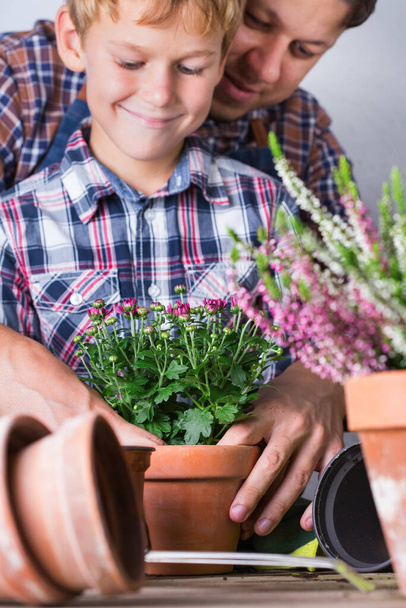 Il bambino aiuta a padre piantare fiori. Tempo in famiglia a casa - Foto, immagini