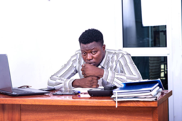 αποθαρρυμένος νεαρός επιχειρηματίας που κάθεται στο γραφείο έχοντας προβλήματα. - Φωτογραφία, εικόνα