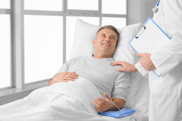 Doctor telling good news to mature man in clinic - Photo, image