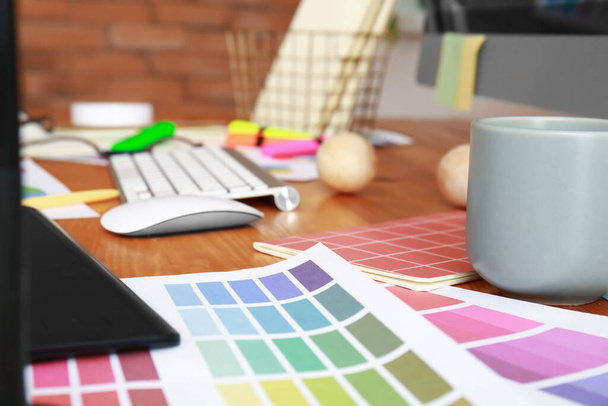 Цветные образцы на рабочем месте графического дизайнера в офисе - Фото, изображение