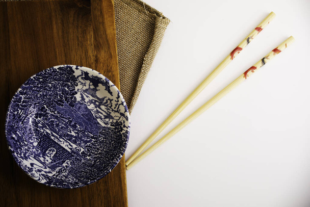 A top view of a patterned bowl and chopsticks on a table - Foto, imagen