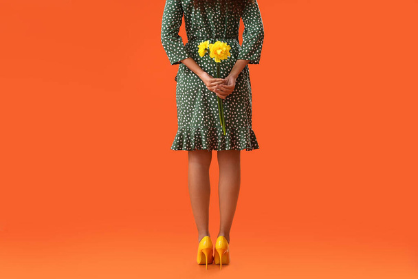 Krásná mladá žena s narcis kytice na barevném pozadí - Fotografie, Obrázek