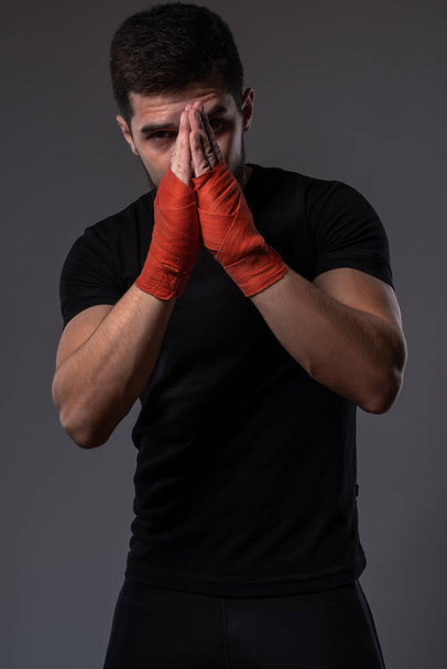 Joven luchador MMA con las manos dobladas para rezar - Foto, Imagen