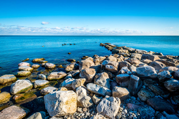 A scenic view of a rocky coast under a clear sky during summertime - Foto, Imagem