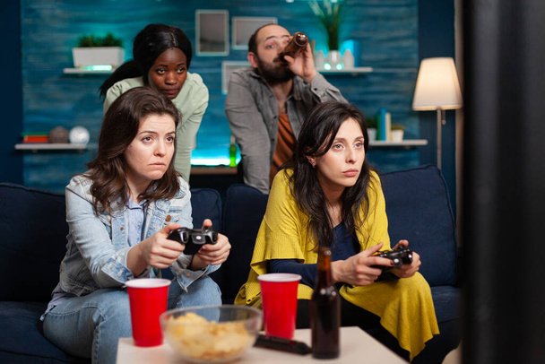 Multi amigos etnicos alegre grupo de personas que se relajan en los juegos de consola - Foto, imagen