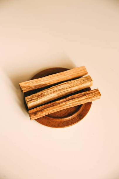 three wooden palo santo sticks on a stand - 写真・画像