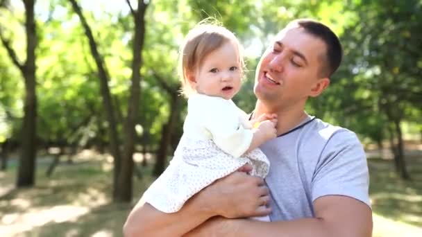 Szczęśliwy młody ojciec spędza czas z małą córeczką na świeżym powietrzu - Materiał filmowy, wideo
