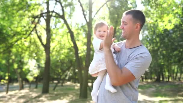 Šťastný mladý otec tráví čas s malou dcerou venku - Záběry, video