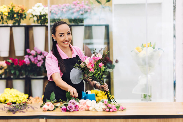 Kwiaciarnia dziewczyna w kwiaciarni robi bukiet na wakacje. Rodzinny biznes kwiat, piękny układ kwiatowy - Zdjęcie, obraz