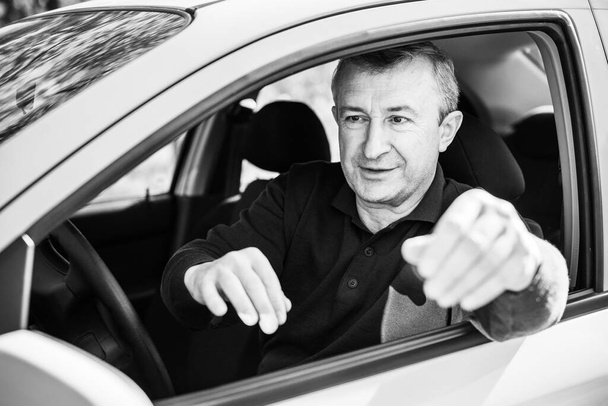 Portrét dospělého muže, jak řídí auto do práce nebo cestuje. Koncept automobilu a populární koníček - Fotografie, Obrázek