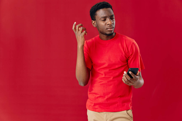 homme apparence africaine avec téléphone dans les mains technologie communication fond isolé - Photo, image