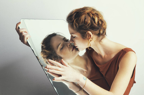 Portrait of the woman with mirror reflection posing in studio  - Foto, Bild