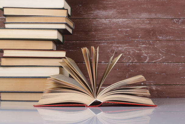 Ciencia y educación - Libro abierto sobre un grupo de libros y antecedentes de madera. Con reflexión - Foto, imagen