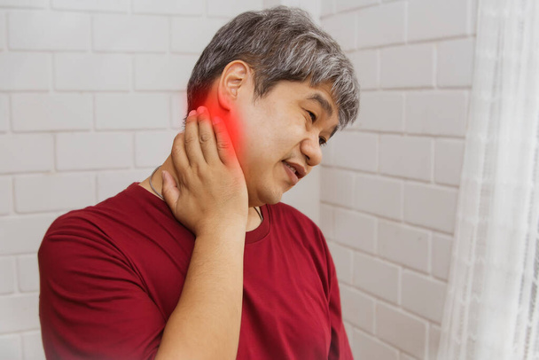 Concepto de cuidado de la salud: Los hombres asiáticos retrato tienen dolor crónico en el cuello de la región occipital y tratan de masajearlo para aliviar el dolor. - Foto, imagen