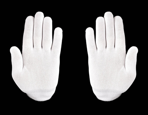 Siyah arka planda beyaz eldivenli el. Beyaz eldivenli bir el siyah arka planda dur işareti gösterir. - Fotoğraf, Görsel