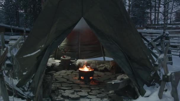 Vista de uma lareira aberta em uma lareira de ferro no meio de uma tenda coberta wigwam no pátio de inverno - Filmagem, Vídeo
