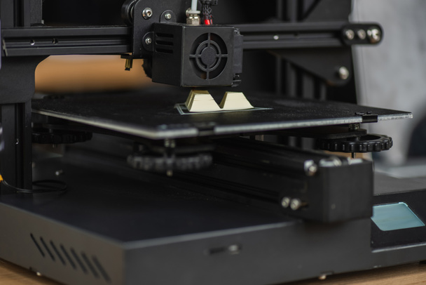 vista de cerca de la impresora 3D la creación de un modelo de plástico sobre fondo borroso - Foto, Imagen