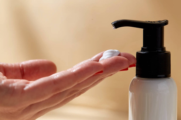 close up of hands with bottle of body lotion - Φωτογραφία, εικόνα