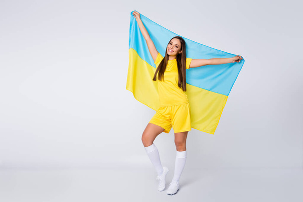 Full length body size view of her she nice beautiful glad cheerful straight-haired girl fan holding in hands Ukrainian flag celebrating holiday isolated over light white gray pastel color background - Foto, immagini