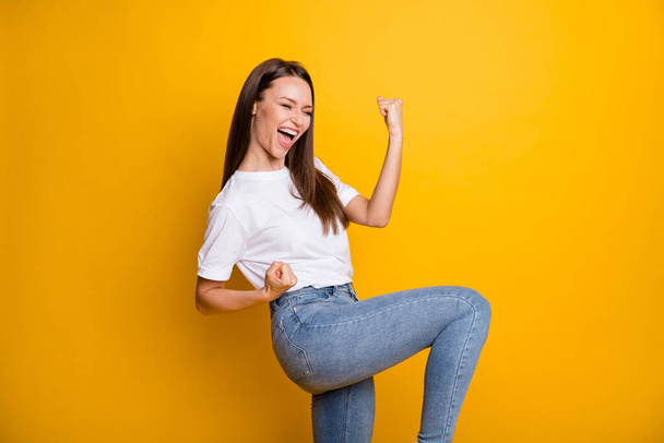 Photo portrait of celebrating screaming woman isolated on bright yellow colored background - 写真・画像