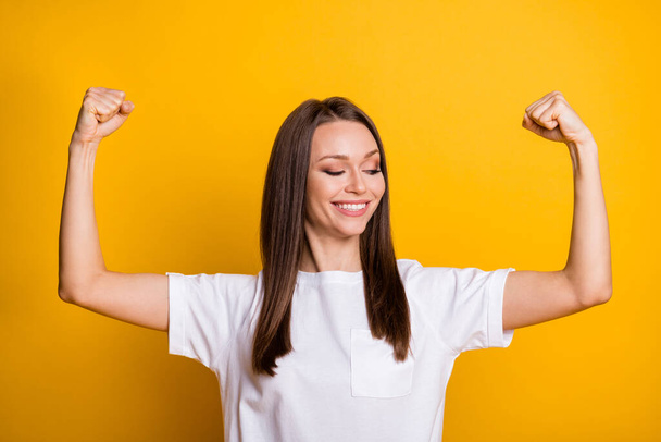 Photo portrait of fit woman showing biceps isolated on vivid yellow colored background - Foto, imagen