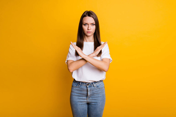 Фотопортрет серьезной девушки с запретом со скрещенными руками изолирован на ярко-желтом фоне - Фото, изображение
