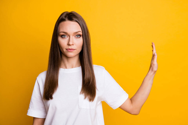 Photo portrait of young serious girl demonstrating prohibition gesture with palm isolated on bright yellow color background with copyspace - Photo, image