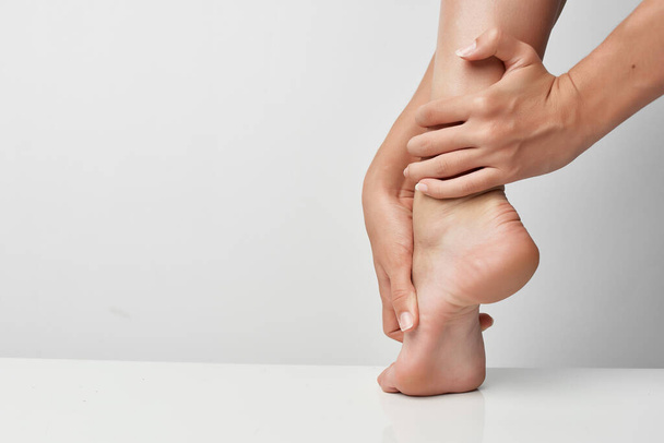 femme massage des jambes douleur articulaire blessure close-up - Photo, image