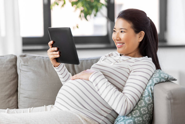 happy pregnant asian woman with tablet pc at home - Фото, зображення