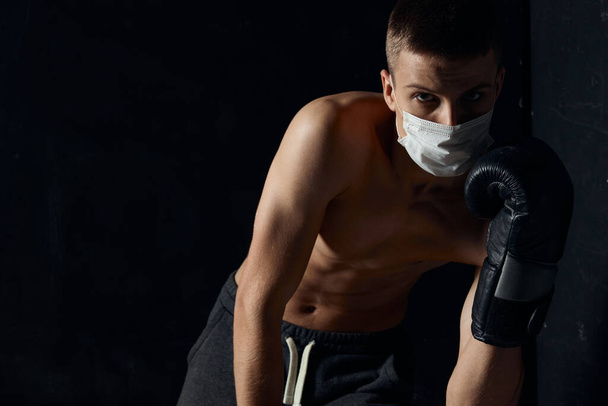 Tıbbi maskeli adam çıplak gövde sporcusu siyah arka plan - Fotoğraf, Görsel